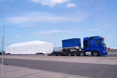 Long vehicle. Over-standard, atypical road transport. A very long and heavy load on a specialized semi-trailer. Exceptional convoy.