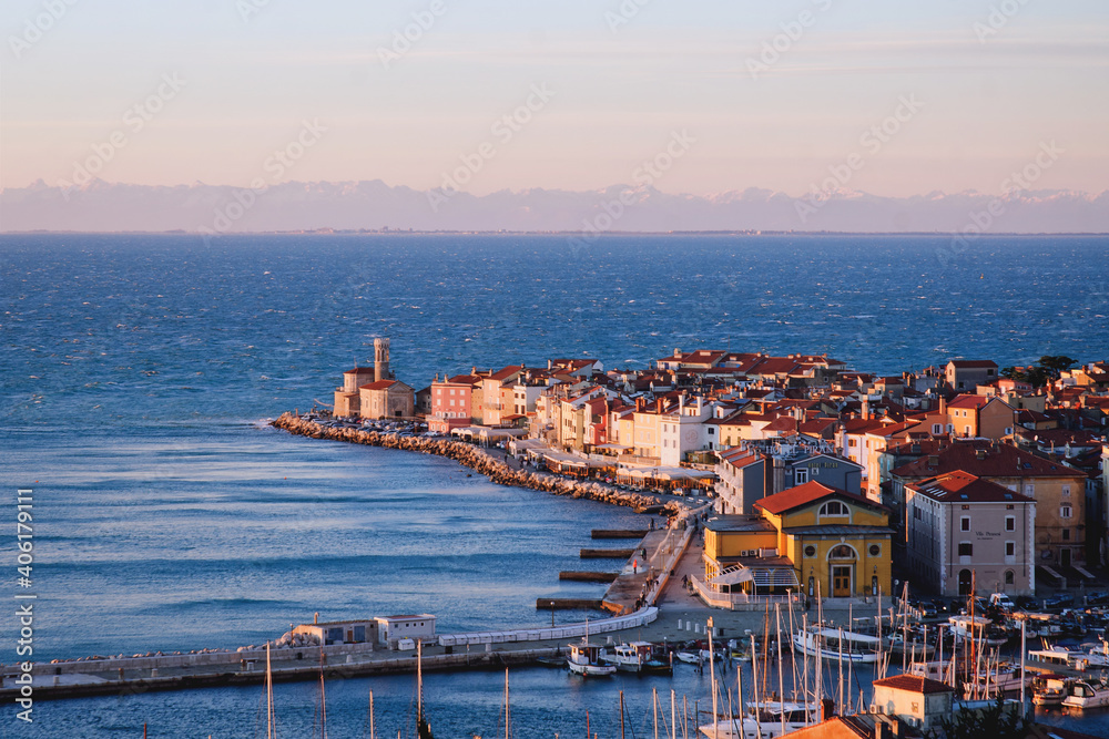 Piran, Picturesque seaside old  town in Slovenia against snow covered alps mountains in winter.