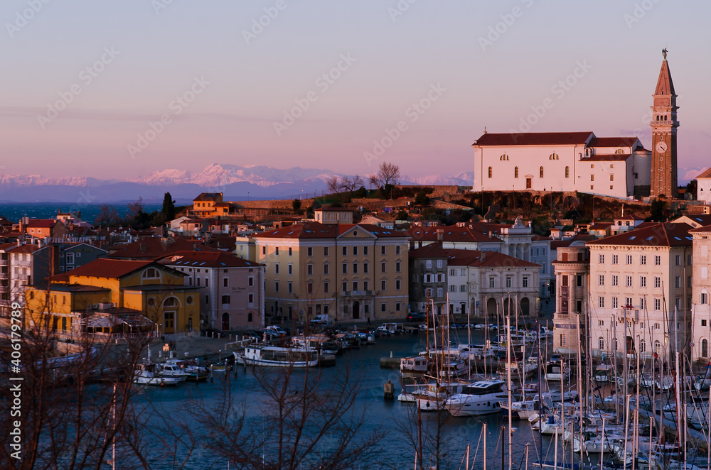 Red roofs of the historical center of old town Piran with main church against the sunset sky and Adriatic sea. Aerial view, Slovenia