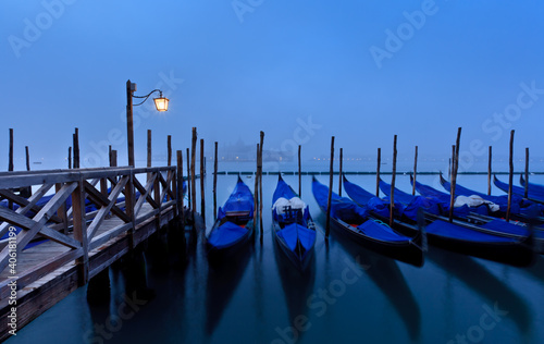 Gondolas tied up at San Marco with San Giorggio Maggiore in the distance, Venice, Veneto, Italy photo