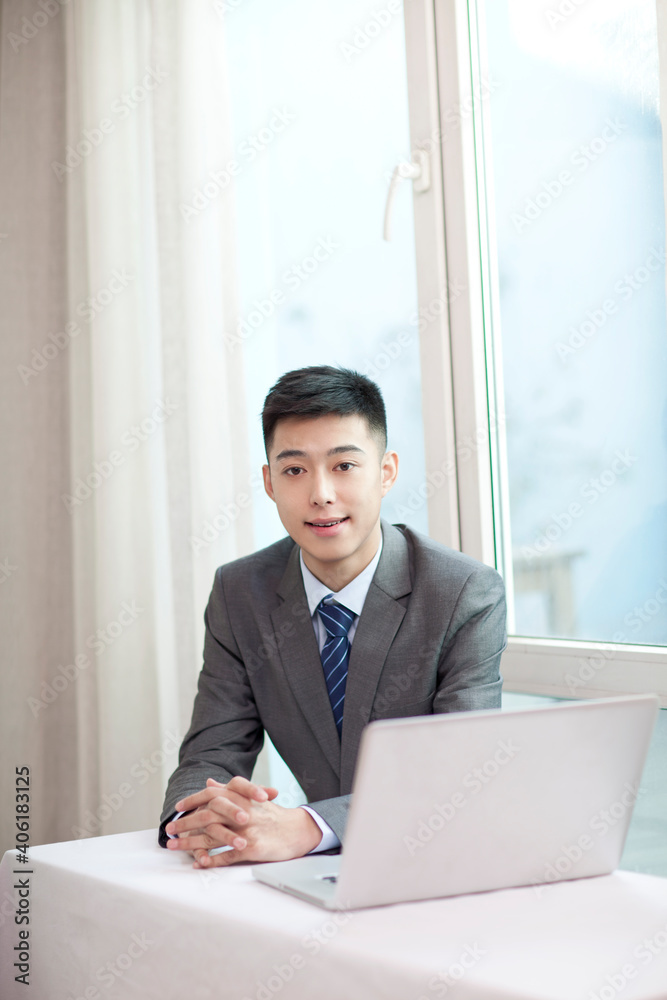 Portrait of young bisinessman sitting in the front of laptop Portrait of young bisinessman sitting in the front of laptop