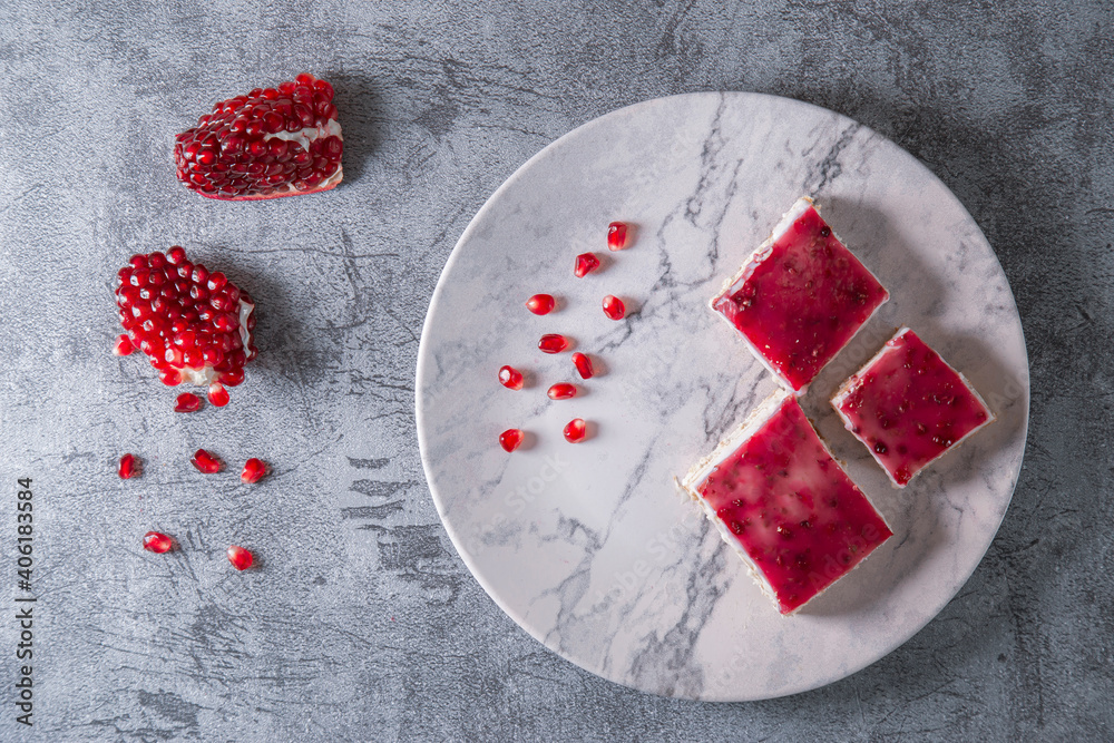 Flat lay view of pomegranate dessert over grey stone backdrop Flat lay view of pomegranate dessert over grey stone backdrop