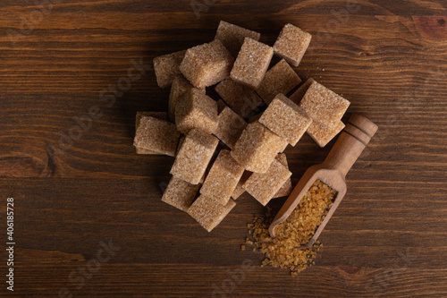Cubes of cane sugar and a wood spoon with sugar