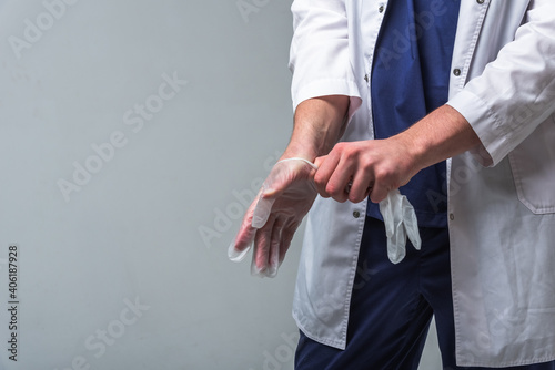 Closeup of a doctor's hands in medical clothing who puts gloves on his hands. Health and protection concept