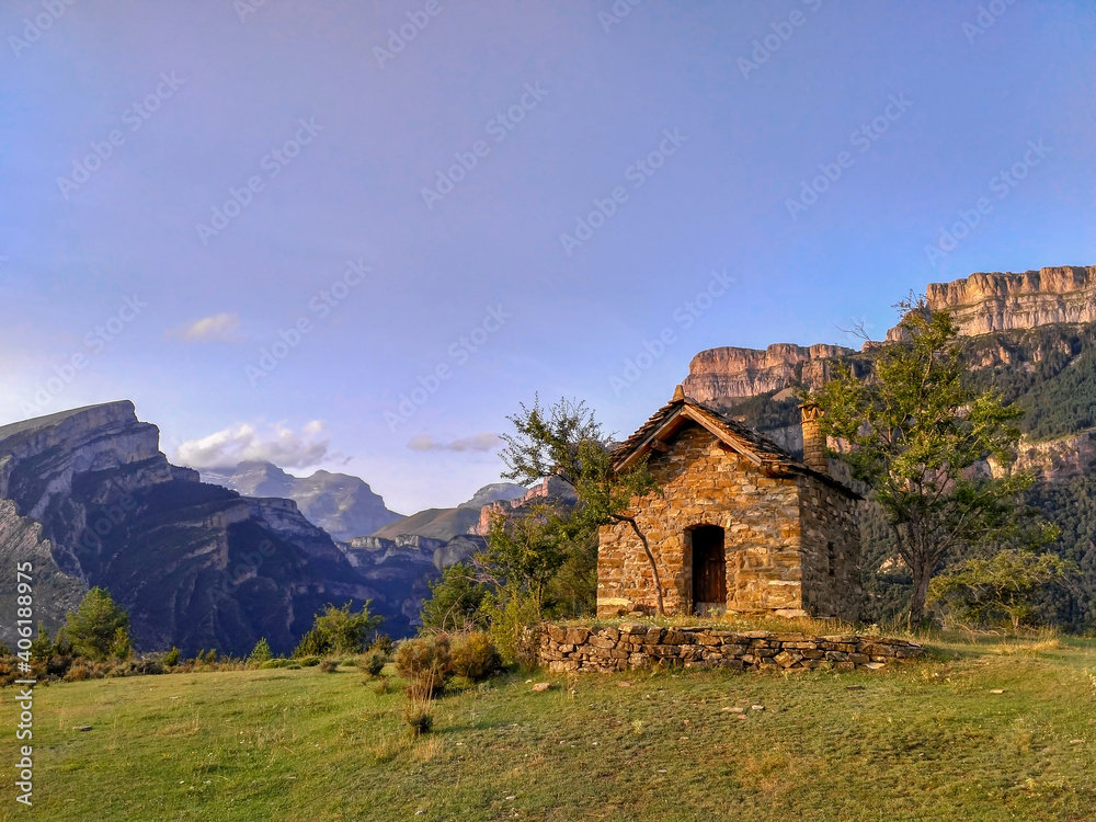 Pequeña casa en lo alto de una montaña con fondo de montaña y cielo Pequeña casa en lo alto de una montaña con fondo de montaña y cielo