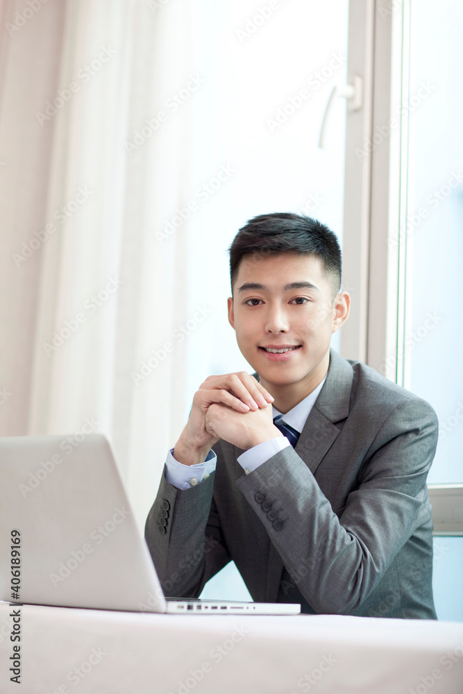 Portrait of young bisinessman sitting in the front of laptop Portrait of young bisinessman sitting in the front of laptop