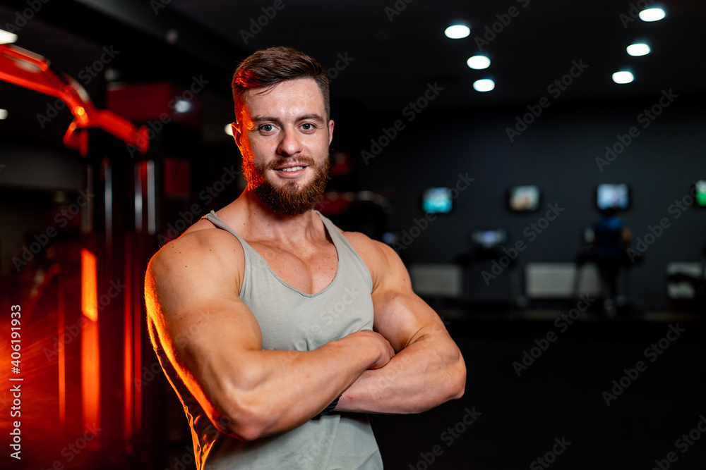 Muscle athlete strongman poses crosshands. Perfect torso with strong abs. Handsome power male on gym background. Muscle athlete strongman poses crosshands. Perfect torso with strong abs. Handsome power male on gym background.
