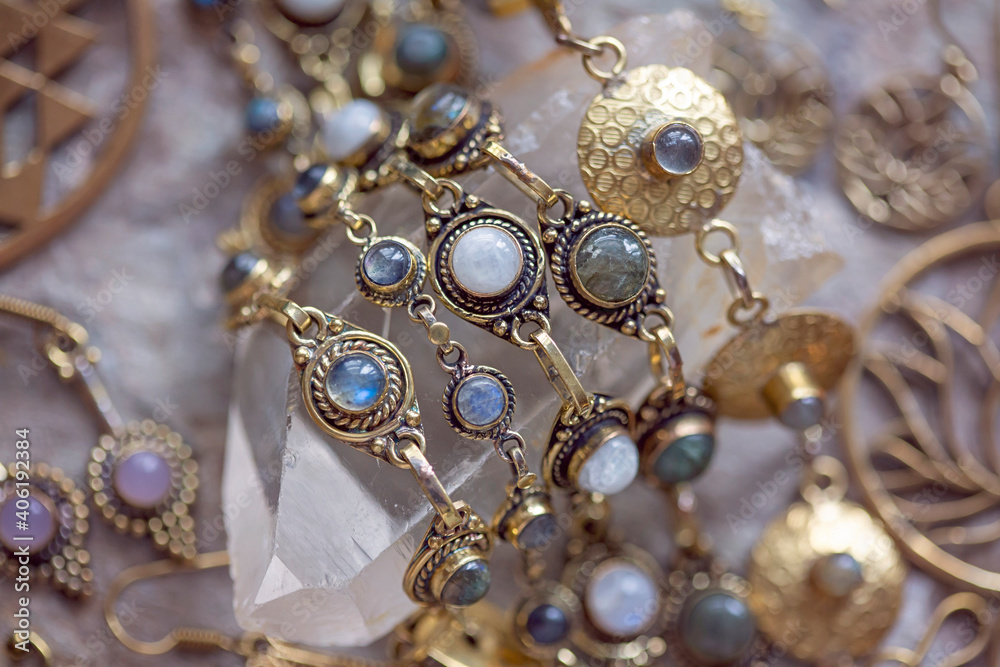 Brass jewelry with natural mineral gemstones on natural rocky background Brass jewelry with natural mineral gemstones on natural rocky background