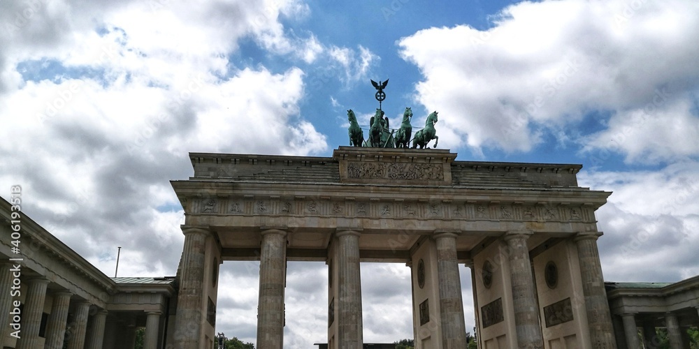 Obraz premium Brandenburg Gate with quadriga against blue sky with clouds