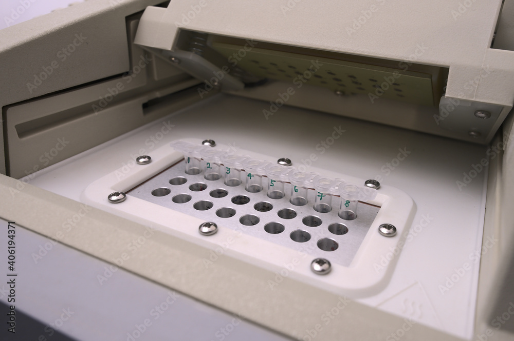 Samples inside a PCR machine used in laboratory testing and experimentation; strip tubes inside a thermocycler with no hands Samples inside a PCR machine used in laboratory testing and experimentation; strip tubes inside a thermocycler with no hands