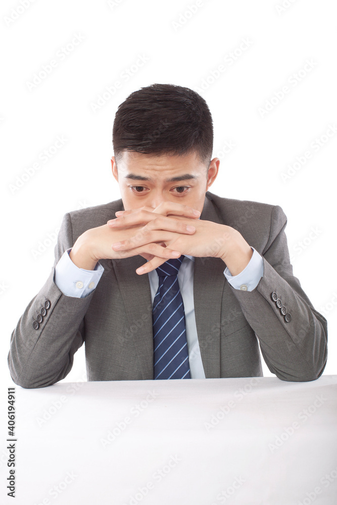 Portrait of young bisinessman with hands crossed in front of mouth Portrait of young bisinessman with hands crossed in front of mouth