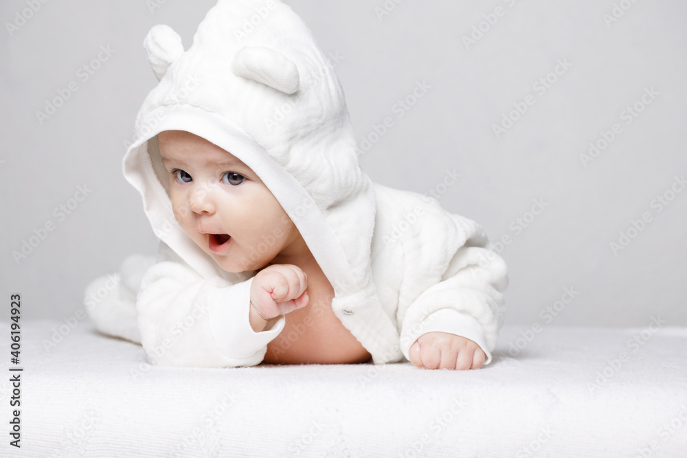 Adorable newborn baby in a soft suit on white background. Free space for text. Child looking at camera and expresses emotions. Adorable newborn baby in a soft suit on white background. Free space for text. Child looking at camera and expresses emotions.
