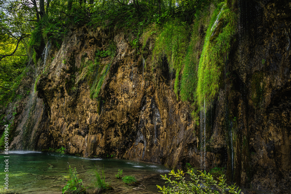 Streaks of water coming down from lichens hooked at tall cliff or waterfall in Plitvice Lakes National Park UNESCO World Heritage, Croatia Streaks of water coming down from lichens hooked at tall cliff or waterfall in Plitvice Lakes National Park UNESCO World Heritage, Croatia