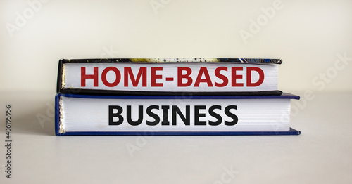 Home-based business symbol. Books with words 'home-based business' on beautiful white table. White background. Business and home-based business concept. Copy space. © Dzmitry