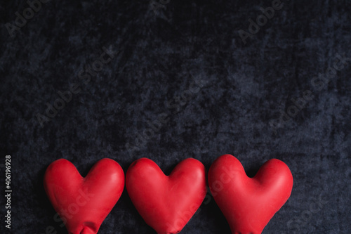 red balloons in the form of a heart on a black background.happy valentines day.  three red hearts on black background