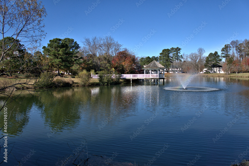 Fountain in a lake with a gazebo in the background