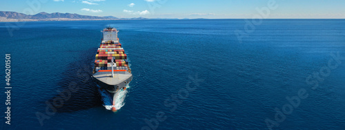 Aerial drone ultra wide photo of huge colourful truck size container tanker vessel cruising deep blue open ocean sea