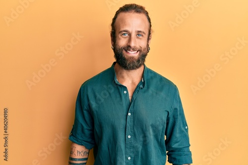 Handsome man with beard and long hair wearing casual clothes with a happy and cool smile on face. lucky person. © Krakenimages.com