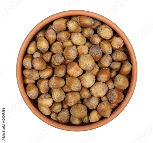 Hazelnuts in clay pot isolated on white background, top view