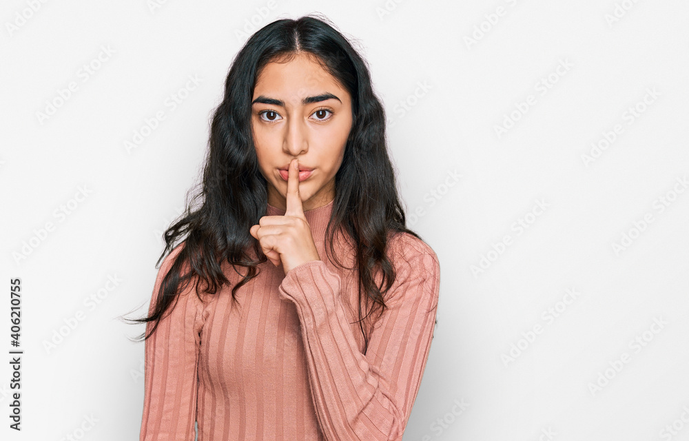 Hispanic teenager girl with dental braces wearing casual clothes asking to be quiet with finger on lips. silence and secret concept. Hispanic teenager girl with dental braces wearing casual clothes asking to be quiet with finger on lips. silence and secret concept.