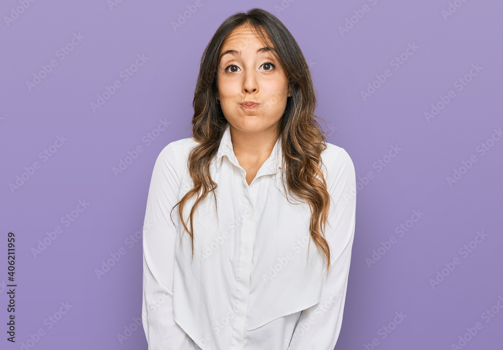 Young brunette woman wearing casual clothes puffing cheeks with funny face. mouth inflated with air, crazy expression. Young brunette woman wearing casual clothes puffing cheeks with funny face. mouth inflated with air, crazy expression.