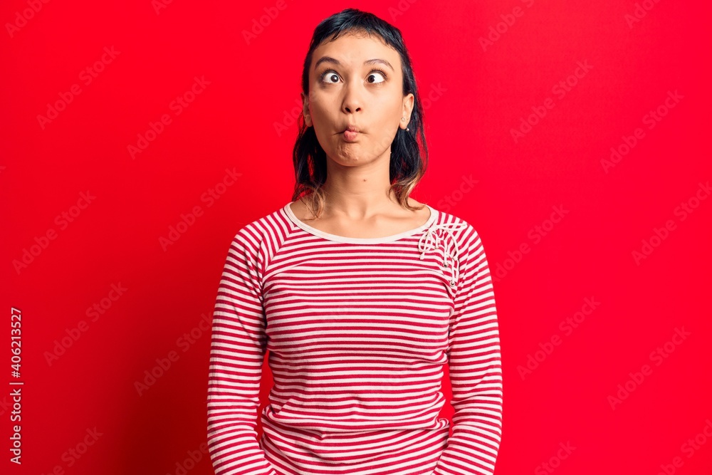 Fototapeta premium Young woman wearing casual clothes making fish face with lips, crazy and comical gesture. funny expression.