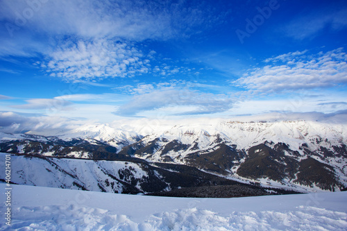 Snow peaks of mountains with blue sky and beautiful clouds. Winter tourism in Russia, Arkhyz. Snow valley on horisontal landscape. © Top Stock Photos