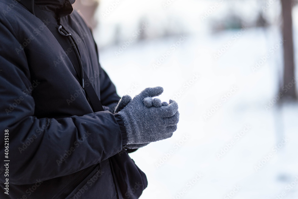 The guy in gloves warms his hands. The guy warms his hands. Hands in gray winter gloves. The palm with the glove in the snow. The guy in gloves warms his hands. The guy warms his hands. Hands in gray winter gloves. The palm with the glove in the snow.