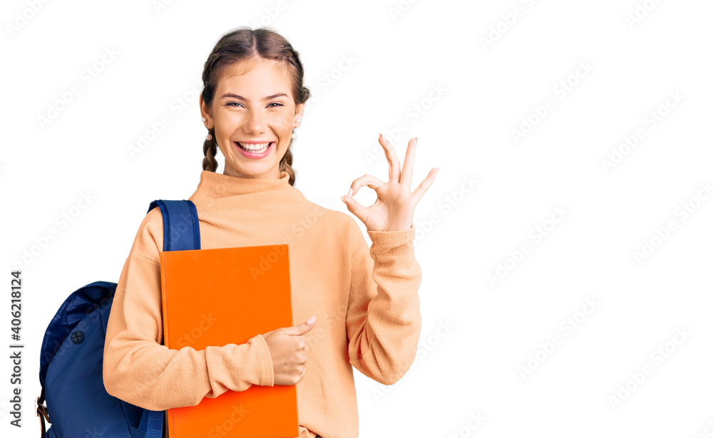 Beautiful caucasian woman with blonde hair wearing student backpack and holding book doing ok sign with fingers, smiling friendly gesturing excellent symbol Beautiful caucasian woman with blonde hair wearing student backpack and holding book doing ok sign with fingers, smiling friendly gesturing excellent symbol