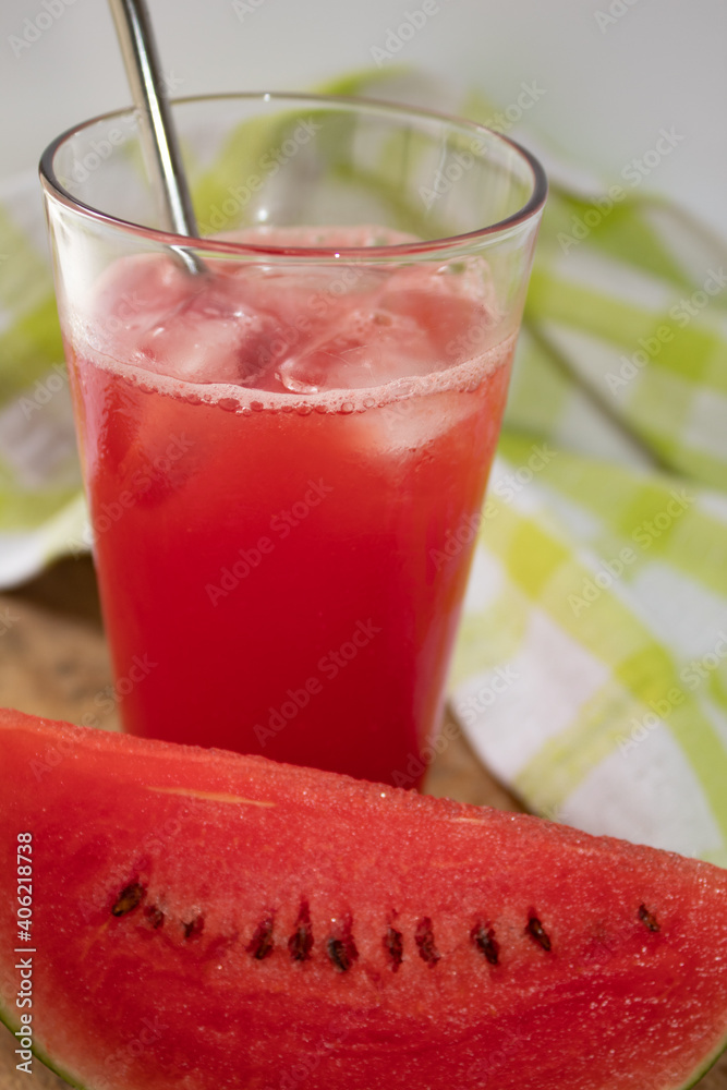 Refreshing watermelon juice with piece of fruit in front Refreshing watermelon juice with piece of fruit in front