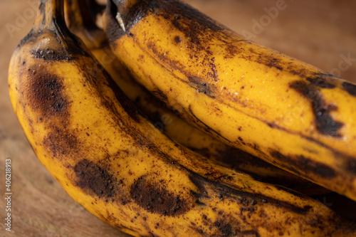 Close-up of bunch with overripe bananas on wooden board