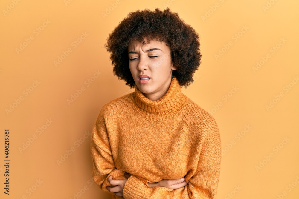 Young hispanic girl wearing wool winter sweater with hand on stomach because nausea, painful disease feeling unwell. ache concept. Young hispanic girl wearing wool winter sweater with hand on stomach because nausea, painful disease feeling unwell. ache concept.