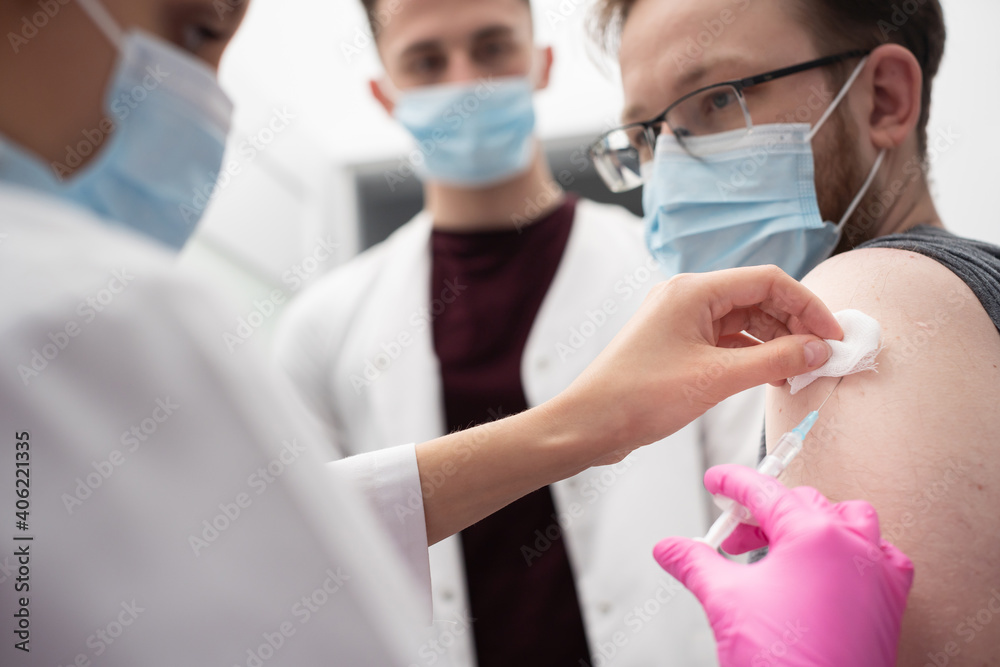 A young nurse shows a medical intern how to properly administer the injections. A sterile doctor's office in a private clinic. The COVID vaccine19. A young nurse shows a medical intern how to properly administer the injections. A sterile doctor's office in a private clinic. The COVID vaccine19.