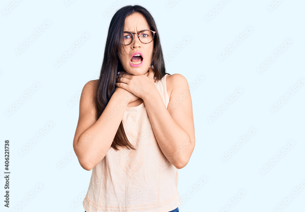 Young beautiful caucasian woman wearing casual clothes and glasses shouting and suffocate because painful strangle. health problem. asphyxiate and suicide concept. Young beautiful caucasian woman wearing casual clothes and glasses shouting and suffocate because painful strangle. health problem. asphyxiate and suicide concept.
