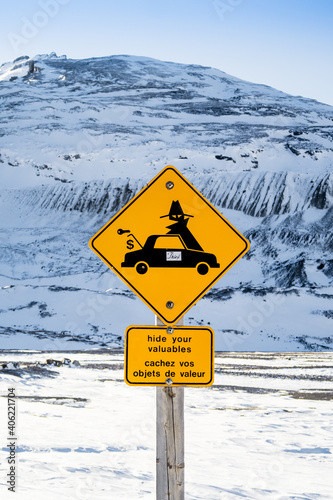 Warning road sign "Hide your valuables" located at the Athabasca Glacier touristic site, in the Canadian Rockies