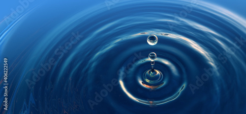 Clear blue water drop with rings and small waves.