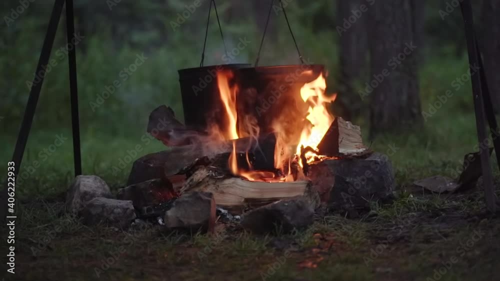Night bonfire prepares food at a picnic in the forest. Night bonfire prepares food at a picnic in the forest.
