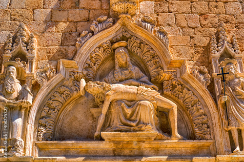 A religious sculpture composition at entrance to the medieval church in Dubrovnik, Croatia.