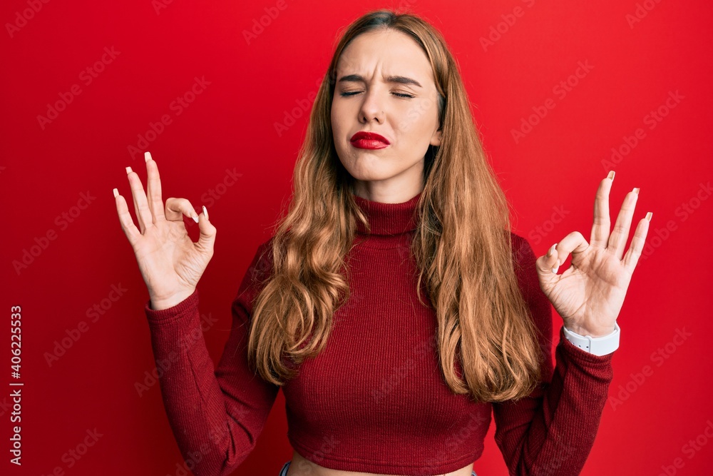 Young blonde woman wearing turtleneck sweater relax and smiling with eyes closed doing meditation gesture with fingers. yoga concept. Young blonde woman wearing turtleneck sweater relax and smiling with eyes closed doing meditation gesture with fingers. yoga concept.