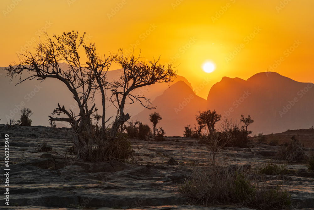 The sun setting over mountains in the desert of Oman.