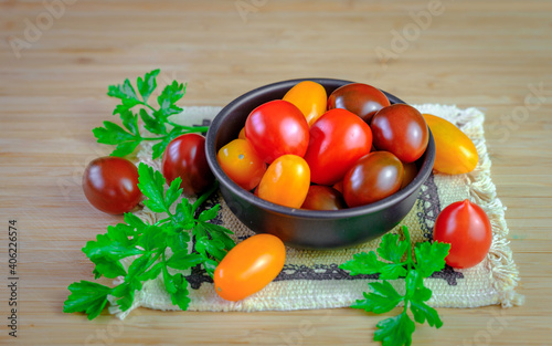 Red, Yellow, Orange Grape Tomatoes in a Bronze Bowl on Bamboo Cutting Board