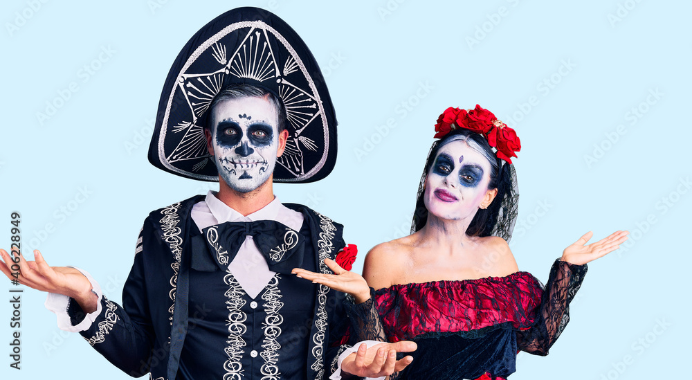 Young couple wearing mexican day of the dead costume over background smiling showing both hands open palms, presenting and advertising comparison and balance Young couple wearing mexican day of the dead costume over background smiling showing both hands open palms, presenting and advertising comparison and balance