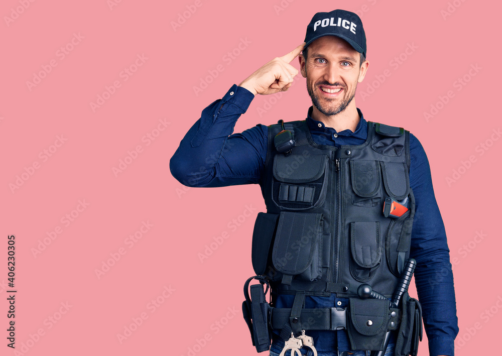 Young handsome man wearing police uniform smiling pointing to head with one finger, great idea or thought, good memory Young handsome man wearing police uniform smiling pointing to head with one finger, great idea or thought, good memory