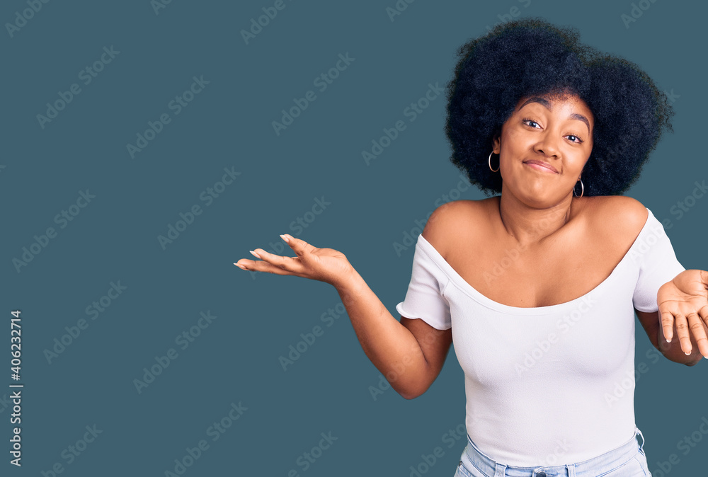 Young african american girl wearing casual clothes clueless and confused expression with arms and hands raised. doubt concept. Young african american girl wearing casual clothes clueless and confused expression with arms and hands raised. doubt concept.