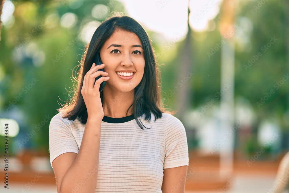 Young hispanic woman smiling happy talking on the smartphone at the city. Young hispanic woman smiling happy talking on the smartphone at the city.