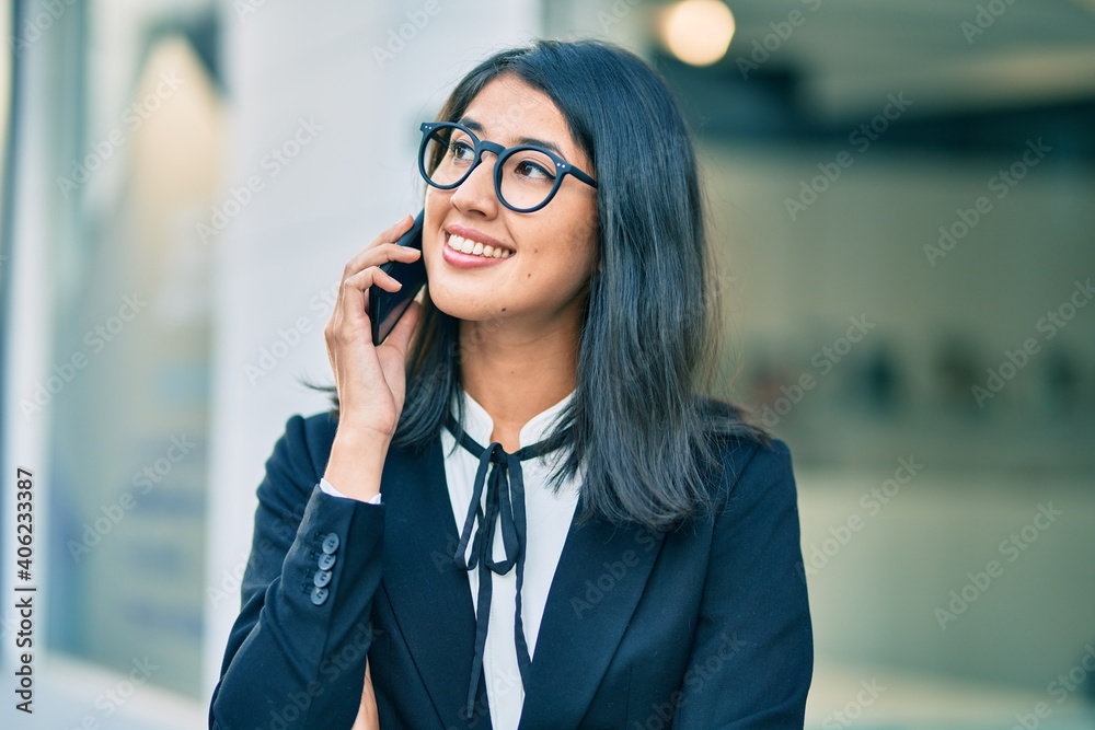 Young hispanic businesswoman smiling happy talking on the smartphone at the city. Young hispanic businesswoman smiling happy talking on the smartphone at the city.