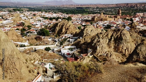 Aerial view of underground dwellings district in Spanish city of Guadix with historic fortified Moorish Castle in background, Andalusia