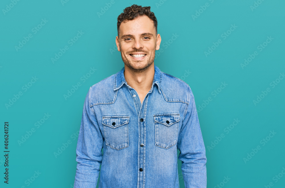 Young hispanic man wearing casual denim jacket with a happy and cool smile on face. lucky person. Young hispanic man wearing casual denim jacket with a happy and cool smile on face. lucky person.