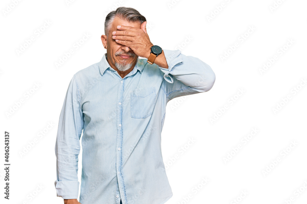 Middle age grey-haired man wearing casual clothes covering eyes with hand, looking serious and sad. sightless, hiding and rejection concept Middle age grey-haired man wearing casual clothes covering eyes with hand, looking serious and sad. sightless, hiding and rejection concept