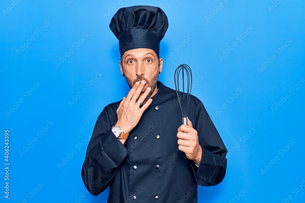 Young handsome man wearing cooker uniform holding whisk covering mouth with hand, shocked and afraid for mistake. surprised expression Young handsome man wearing cooker uniform holding whisk covering mouth with hand, shocked and afraid for mistake. surprised expression